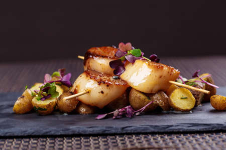 Grilled scallops with roasted young potatoesの写真素材