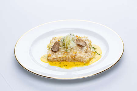 Risotto with truffles and corn sauce in white plateの写真素材