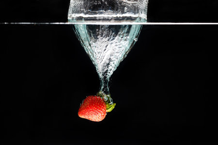A strawberry splashing into water