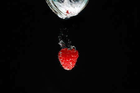 A strawberry splashing into waterの写真素材