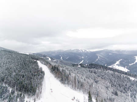 Aerial view of forest in the winter during the snowfall in the area of Bucovel in Ukrain. Captured from above with a drone.の写真素材