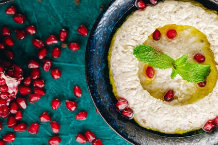 Hummus in the bowl surrounded with vegetables and seedsの写真素材