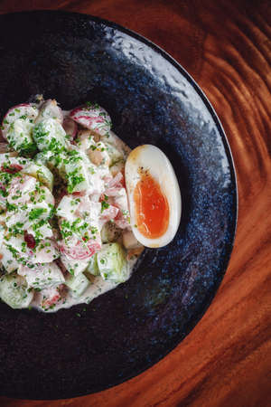 Vegetable salad with boiled eggs mixed with sour creamの写真素材