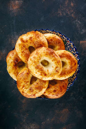 Traditional Uzbek bread with sesame served in colourful plateの写真素材