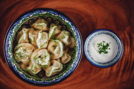 Traditional russian pelmeni, ravioli, dumplings with meat on wooden background.の写真素材