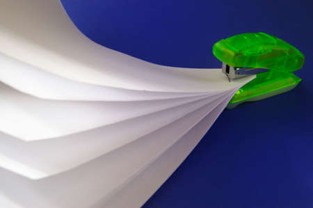 Stapler and documents on a dark blue background の写真素材