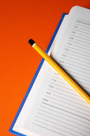 Notebook and pen on dark red background