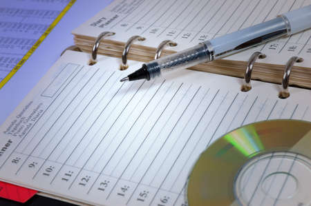 Pen and cd atop of the opened notebookの写真素材