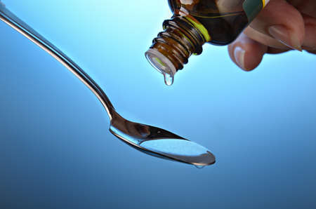 Drop of a medicine bottle On a dark blue backgroundの写真素材