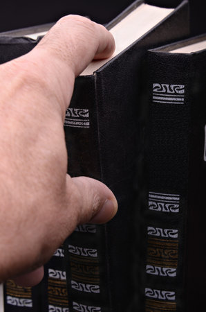 Hand taking the book against a dark background