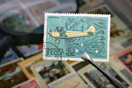 old postage stamp tweezers to open the album on the backgroundの写真素材