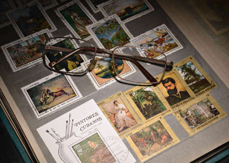 open album with colorful stamps and glasses, a collection of philatelistの写真素材
