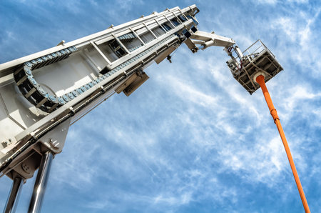A hydraulic man lift extends up to  blue sky