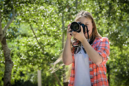 Portrait of a young teen girl with cameraの写真素材