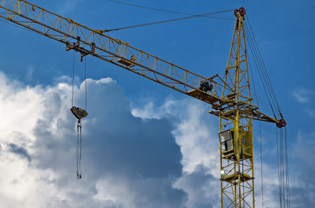Tower cranes on the construction of a residential building on a background of blue sky
