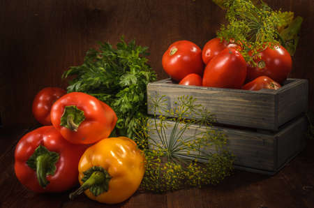 bell peppers and other vegetables on a dark wooden background in a rustic styleの写真素材