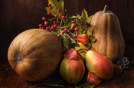 ripe pears and pumpkin on a dark wooden background in a rustic style