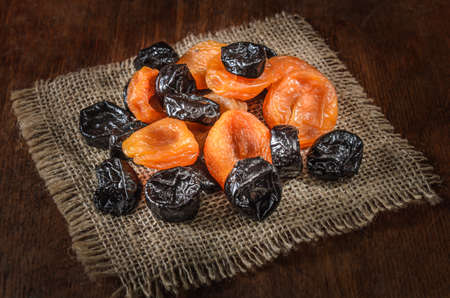 dried apricots and other dried fruits on a dark wooden backgroundの写真素材