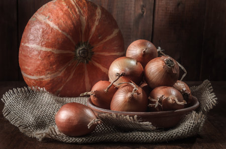 onion and pumpkin on dark wooden backgroundの写真素材