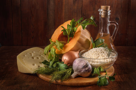pumpkin and ingredients for pumpkin casserole with rice on a dark backgroundの写真素材