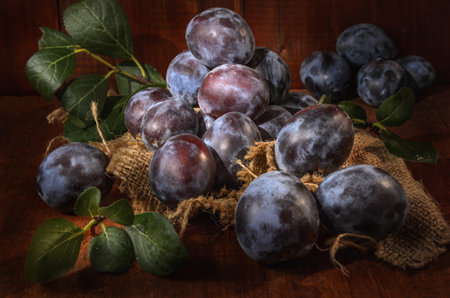 ripe plum on a dark wooden background in a rustic styleの写真素材