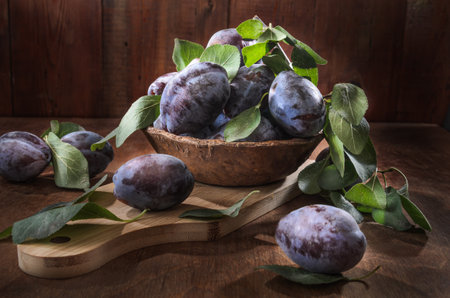 Ripe plum on dark wooden background in rustic styleの写真素材