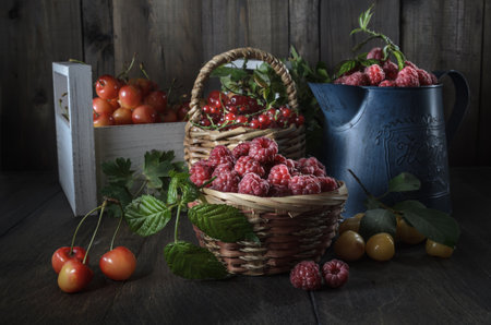 harvest of ripe juicy berries on a dark wooden background in a rustic styleの写真素材