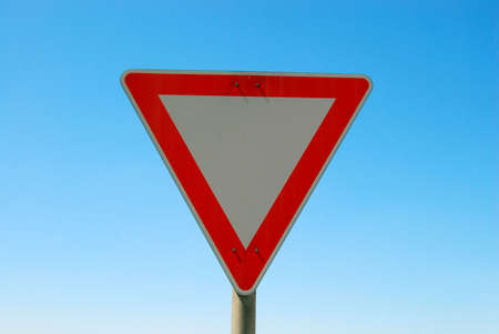 Give way road sign close-up on solid background.の写真素材