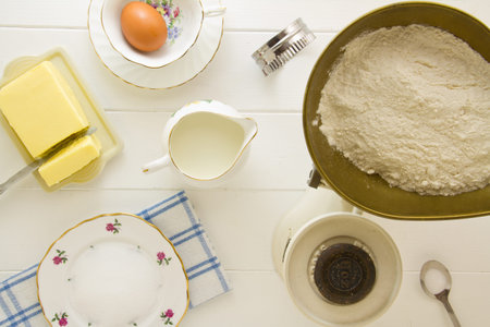 Ingredients for English scones laid out on white wood, above. Part of a series showing the...
