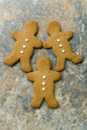 Gingerbread men on a rustic stone surfaceの写真素材