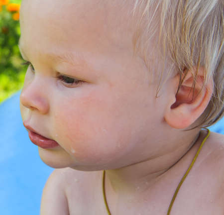 The child is swimming in an inflatable pool in nature.の写真素材