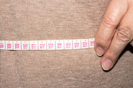 Woman measures waist size. Measurement of waist size.の写真素材