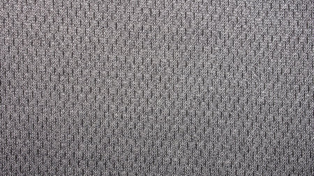 The texture of the fabric is gray with black speckles.Grey background with speckled textiles.