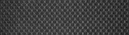 Texture of black fabric embroidered in a checkerboard pattern.Background of dense black fabric...