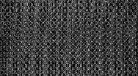 Texture of black fabric embroidered in a checkerboard pattern.Background of dense black fabric...