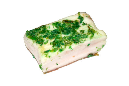 Homemade Ukrainian lard with garlic on a white background.A piece of lard with herbs and garlic.