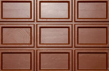 Milk chocolate is divided into blocks top view. Milk chocolate background with rectangular block pattern.の写真素材