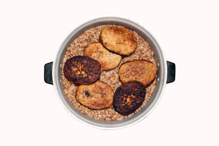 Meat cutlets with buckwheat in a saucepan on a white background. Buckwheat porridge with cutlets in...