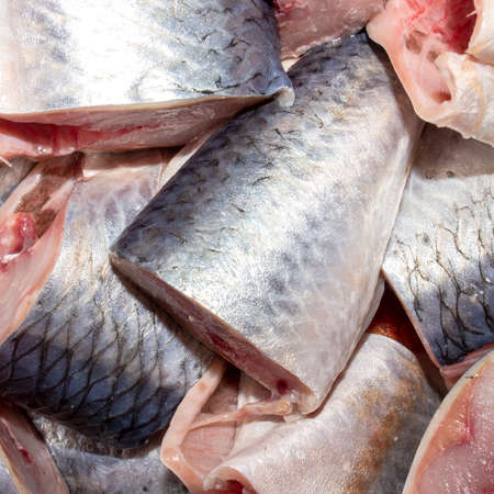Salted herring cut into chunks.Background of pieces of pickled herring top view.の写真素材