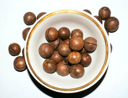 Macadamia nuts in a shell on a white background.Macadamia is a genus of woody plants in the Proteaceae family.の写真素材