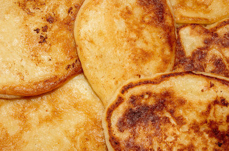Fritters are fluffy tortillas made from yeast dough. Homemade Russian pancakes with a golden crust. Pancakes from the heat. Fritters background. Fried pancakes.の写真素材