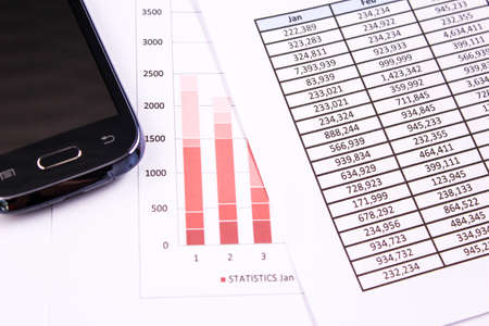 Financial charts on the table with phoneの写真素材