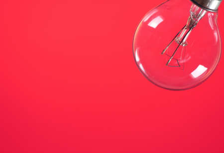 Lightbulb on red backgroundの写真素材