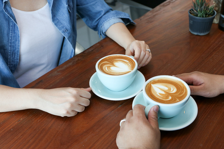 Asian couple in jean shirt have hot latte coffeeの写真素材