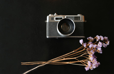 Color film camera with purple flower on black metal desk - Top view with copy spaceの写真素材
