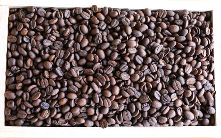 Top view - roasted coffee bean background in wooden containerの写真素材