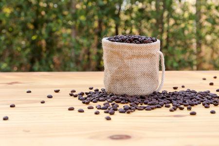 Roasted coffee beans in a small sack with bokeh backgroundの写真素材