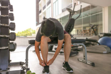 Happy Asian woman work out in gym tie up shoelaceの写真素材
