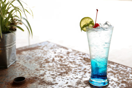 Italian soda, fruity beverage with sliced lemon on rusty black desk