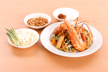 Thai cuisine - Pad Thai, stir-fried rice noodle dish with shrimp on wood backgroundの写真素材